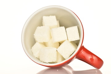 Several cubes of white sugar, close-up, on a white background.