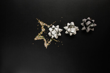 Christmas silver decorations on black background. Flat lay design.