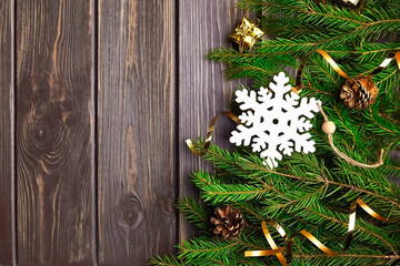 Fir tree branches with christmas decorations on wooden background