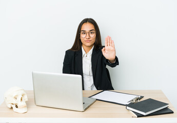 Young traumatologist asian woman isolated on white background standing with outstretched hand showing stop sign, preventing you.