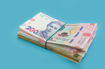 stack with 200 hryvnia on a blue background. Ukrainian money isolated on blue. Financial concept. New banknotes.