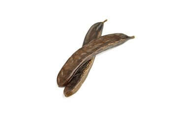 Dried carob tree fruits isolated on white background.
