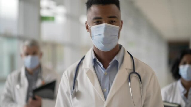 Group of doctors standing in hospital corridor with face mask