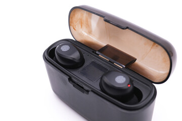 Still life su sfondo bianco di cuffie bluethoot earbuds nere inserite nel supporto di caricamento