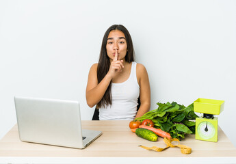 Young dietician asian woman isolated on white background keeping a secret or asking for silence.