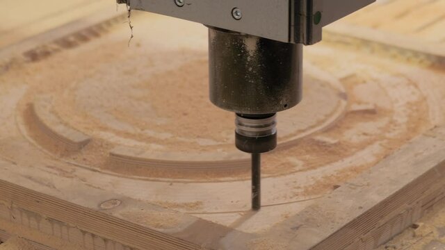 CNC engraving, woodworking, carving, industrial, manufacturing concept. Automated milling machine cutting wooden workpiece from wood pulp, making 3d model at technology exhibition, factory - close up.