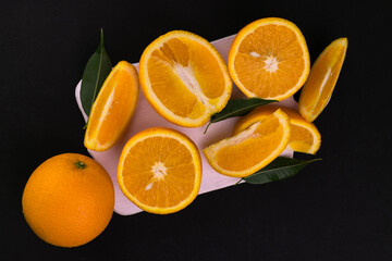 Oranges on a white wooden board on a black background.
Flat lei.