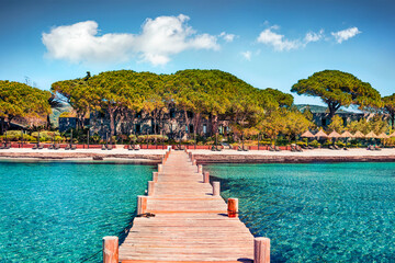 Beautiful landscape with wooden pier on Santa Giulia beach. Nice morning scene of Corsica island, France. Stunning Mediterranean seascape. Traveling concept background..