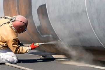 View of the sandblasting or abrasive blasting. Abrasive blasting, more commonly known as sandblasting, is the operation of forcibly propelling a stream of abrasive material against a surface.