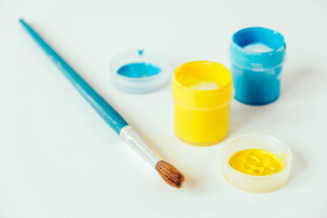 Colorful gouache paints and brush for painting on white background. Copy, empty space for text