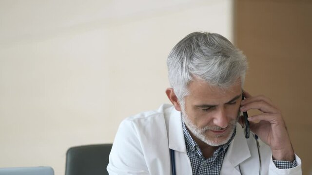 Portrait of doctor in hospital office working laptop