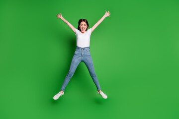Fototapeta na wymiar Full body photo of energetic girl jump raise hands isolated over green bright color background