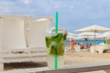 Fresh mojito cocktail on a table on a background of tropical beach