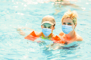Vacation and technology. Happy familyin medical mask with kid together near swimming pool. Tourists fear the 2019-ncov virus. Medical masked tourists