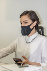 Business woman working in office wearing face mask due to covid19