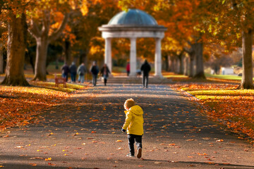 Fototapeta premium A child running down a walking alley in a park in Dublin, Irish National War Memorial Gardens