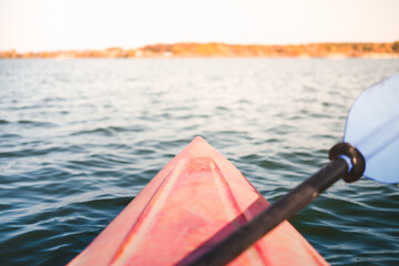Canoe boat nose on the water, big lake. Point of view of person in a kayak on water, active rest, boating vacation