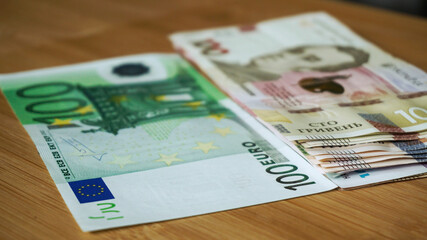 Ukrainian banknote hryvnias stacked against 100 euro banknote , reduction of the hryvnias and the euro close up. currency. Corruption.