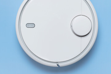 Modern robot vacuum cleaner on blue background flat lay. New technologies, quick house cleaning, automatic robot assistant. Free time to relax. Future technology, smart appliance for cleaning house