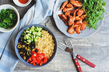 arabian or morrocan cuisine - tabule spicy bulgur salad with olives, bell peppers, cucumbers and grilled chicken breast