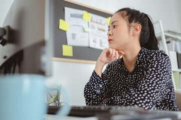 Business woman working and sitting at desk at office, placing chin on her hands and looking away thinking solving problem at work. Business woman and working online concept..