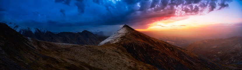 Obraz premium Beautiful Aerial Panoramic View of Dramatic Mountains and Scenic Alpine Lake during Fall in Canadian Nature. Dramatic Colorful Sunset Artistic Render. Tombstone Territorial Park, Yukon, Canada.