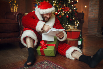 Fototapeta na wymiar Bad drunk Santa claus reads letters, nasty man