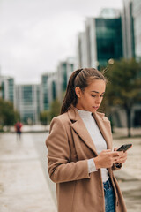 Fototapeta premium Girl walking and holding her smart phone.