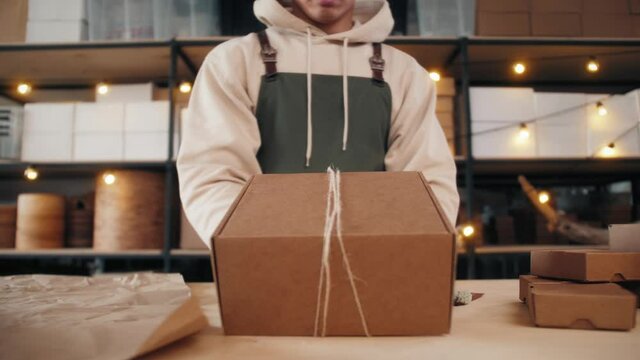Man packing Gift boxes in e-commerce shop or store for delivery, natural packaging materials, Christmas and New year decor, factory and stock, online shopping