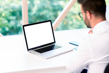 Businessman sitting behind his blank screen computer at desk