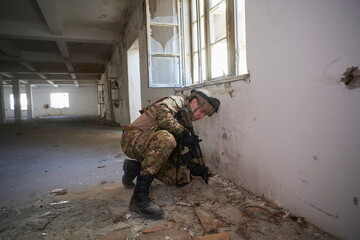 soldier in action near window changing magazine and take cover