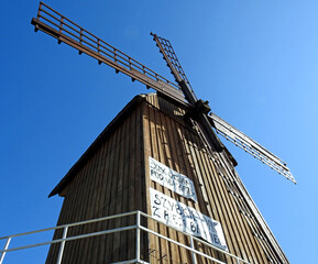 Grain mill Kozlak windmill standing by the Bug River in the village of Brok in Masovia, Poland on a white background an inscription advertising grandma's kitchen