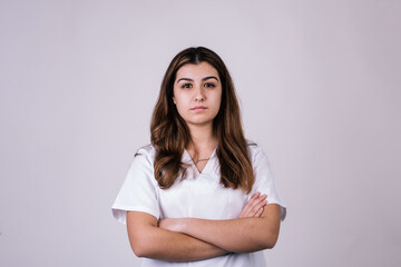 portrait of white woman dressed in a nurse coat on a white background. Her hair is brown. She has...