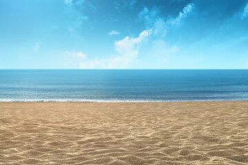 Background of a sandy beach with sea and blue sky on a summer day