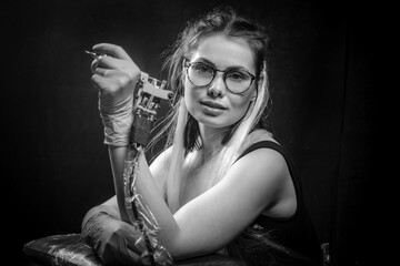 Master of the art of tattooing and a tattoo machine in his salon