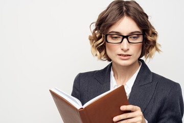 Business woman with notepad and glasses work light background cropped view of suit model.