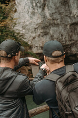 Fototapeta premium Nice mountain views at Plitvice Lakes Park. Croatia. Two guys tourists take a photo of the cave
