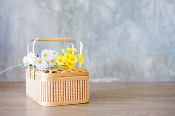 Fototapeta na wymiar white and yellow flowers in a wooden basket