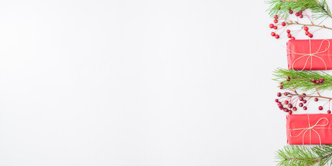 Flat lay border with red christmas decoration, pine branches and gift box on a white background