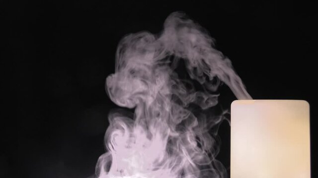 Air humidifier and smoke on the black background