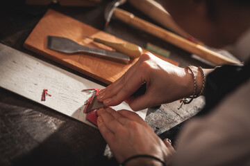 Leather handbag craftsman at work in a vintage workshop. Small business concept