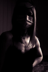 black and white dramatic portrait of young woman in a medical mask