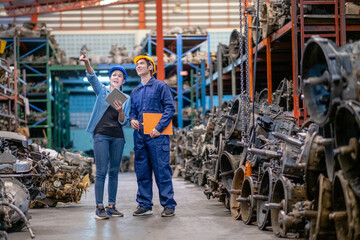 Factory man and woman discuss together with happiness emotion and stand in automotive parts workplace area. Concept of good management and support system for industrial business.