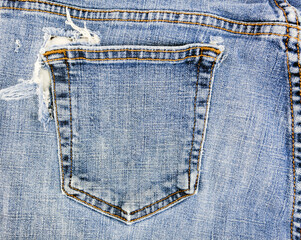 Torn and frayed blue jeans back pocket.