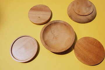 Wooden cup base handmade on yellow background.