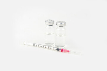 Two vials with medicine and syringe for injection treatment. Covid-19 vaccine concept. Isolated on...