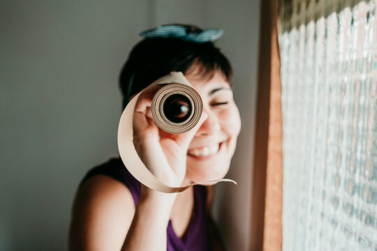 Young woman playing with a roll of paper before painting the walls in white. Do it yourself. Selective focus
