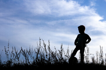 silhouette of a little boy football player