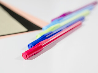 Diagonally positioned colorfuls pens on the white blurred background