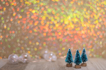Three tiny green evergreen trees on board golden for holiday sale, christmas bokeh background copy space